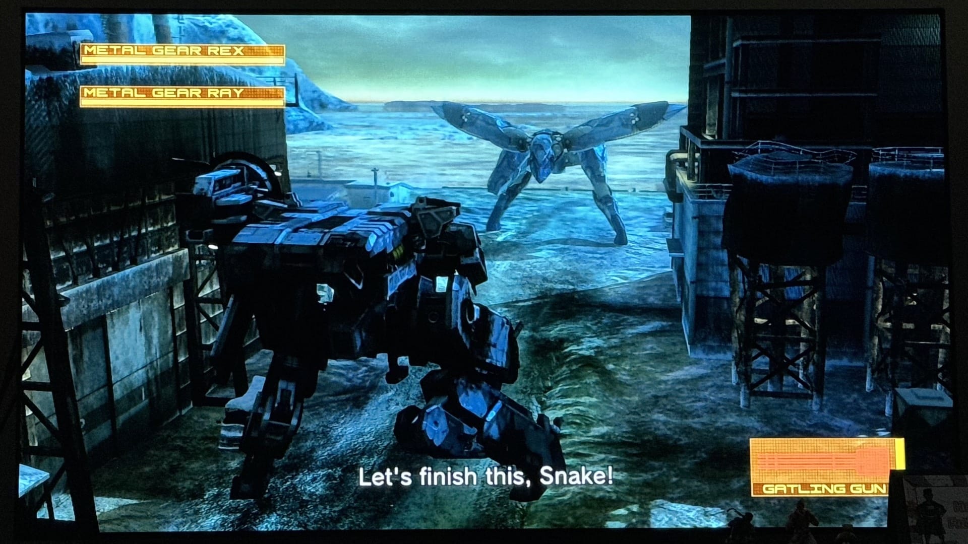 Metal Gear REX facing Metal Gear RAY at Shadow Moses, with the subtitle 'Let's finish this, Snake!'